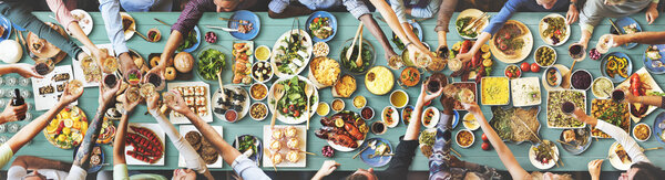 друзья едят за большим столом
