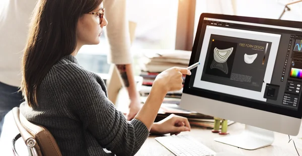 Kvinnan visar på monitor med design — Stockfoto