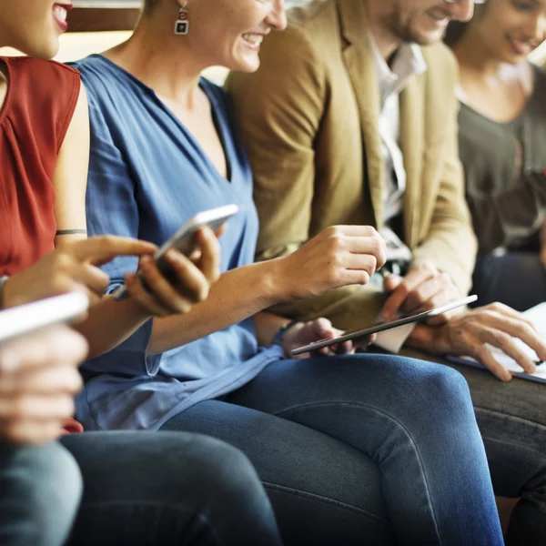 Menschen sitzen mit digitalen Geräten — Stockfoto
