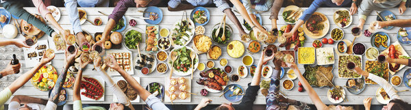 друзья едят за большим столом
