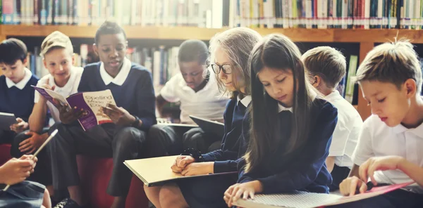 Camarades de classe lisant des livres à la bibliothèque — Photo