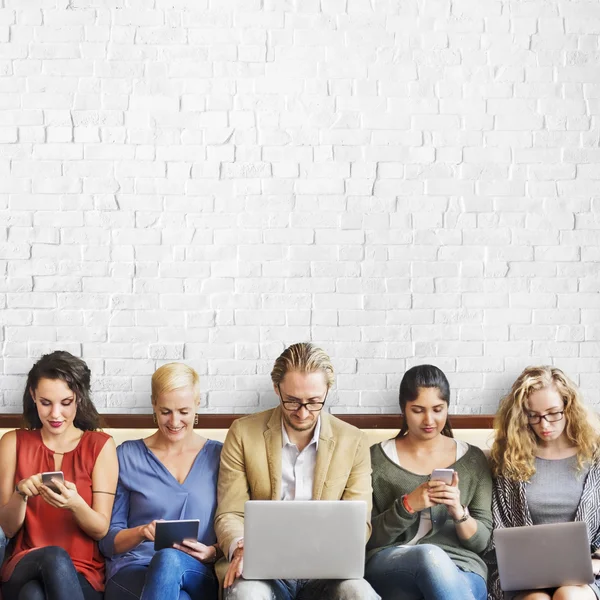 La gente se sienta con varios dispositivos digitales — Foto de Stock