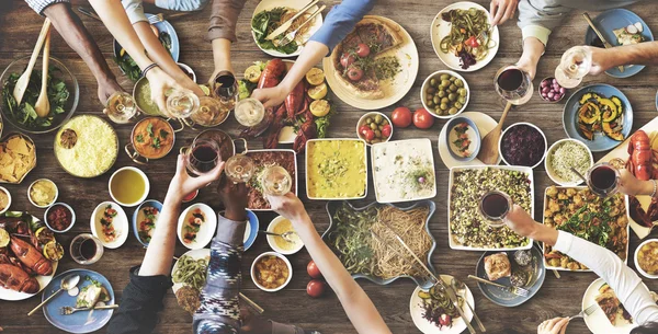 Друзі їдять за великий стіл — стокове фото