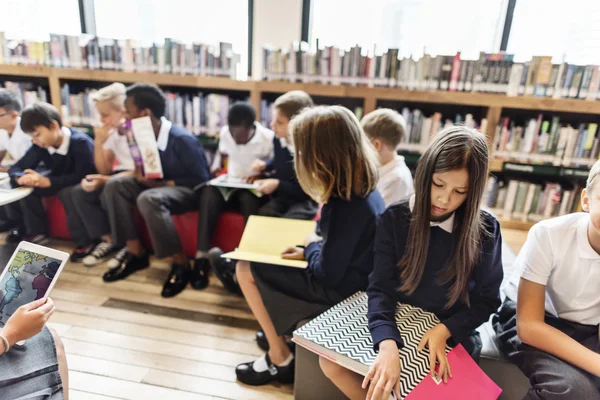 Colegas de classe na biblioteca com livros — Fotografia de Stock