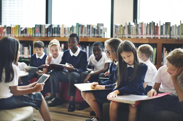 Klasgenoten lezen van boeken in bibliotheek — Stockfoto