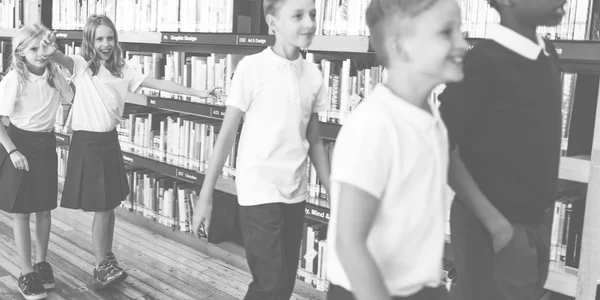 Crianças juntas na biblioteca da escola — Fotografia de Stock