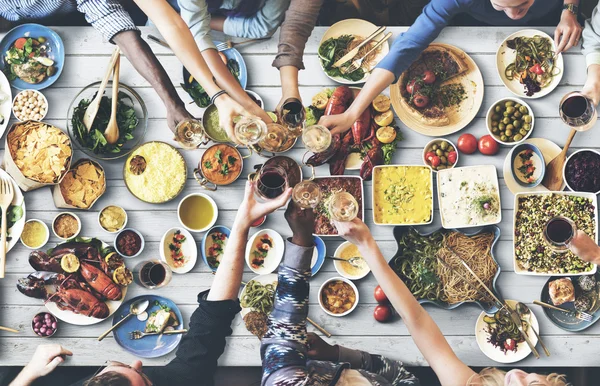 Amigos comiendo para la mesa grande —  Fotos de Stock