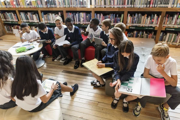 Compagni di classe che leggono libri in biblioteca — Foto Stock