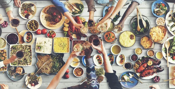 Amigos comendo para grande mesa — Fotografia de Stock