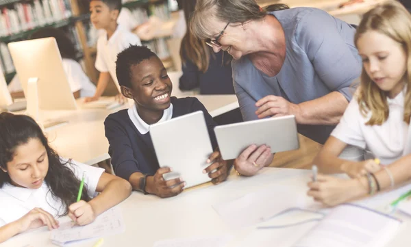 Kinderen die studeren in de bibliotheek — Stockfoto