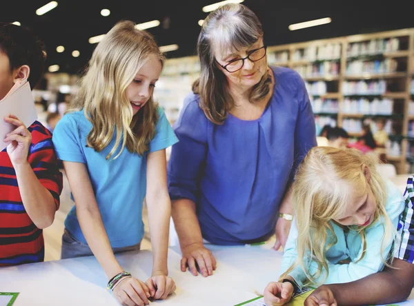 Kinderen die studeren in de bibliotheek — Stockfoto