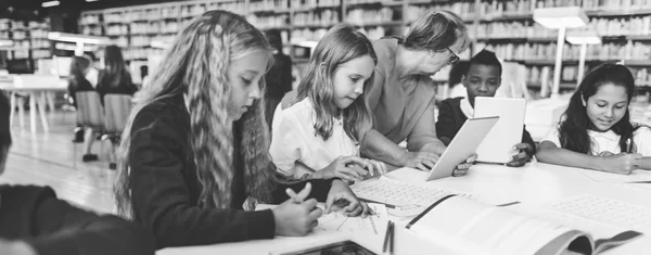 Kinderen die studeren in de bibliotheek — Stockfoto