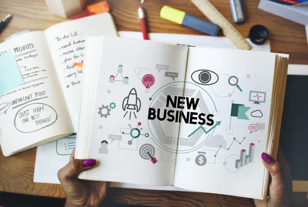 Woman holding book with new business — Stock Photo, Image