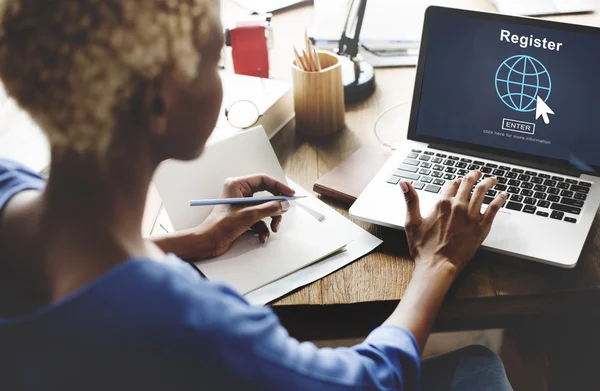 Donna che lavora su computer portatile con registro — Foto Stock