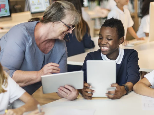 Kinderen die studeren in de bibliotheek — Stockfoto