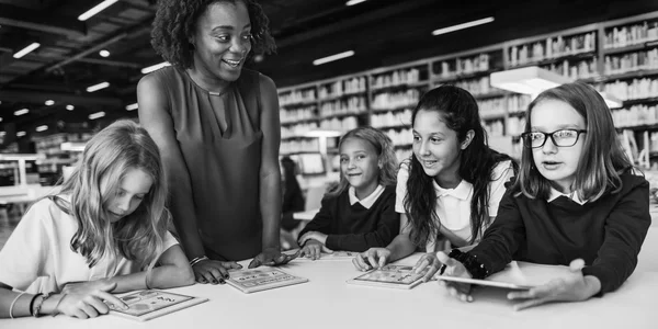 Kinderen die studeren in de bibliotheek — Stockfoto