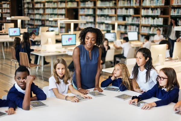 Groep kinderen studeren in de bibliotheek — Stockfoto