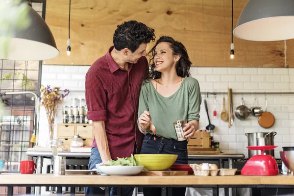 Casal jovem preparar e comer alimentos — Fotografia de Stock