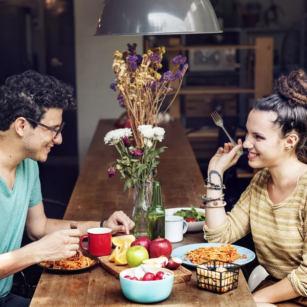 Junges Paar bereitet und isst Essen zu — Stockfoto