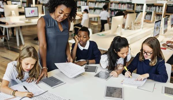 Niños estudiando en la biblioteca —  Fotos de Stock