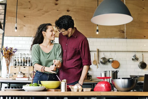 Nuori pari valmistaa ja syödä ruokaa — kuvapankkivalokuva