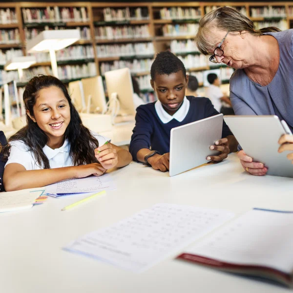 Kinderen die studeren in de bibliotheek — Stockfoto