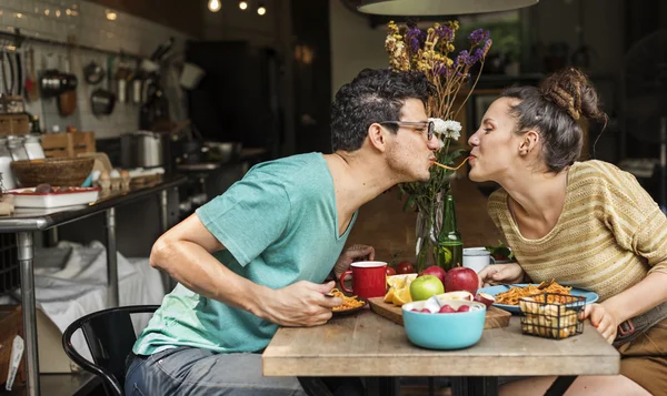 Junges Paar bereitet und isst Essen zu — Stockfoto
