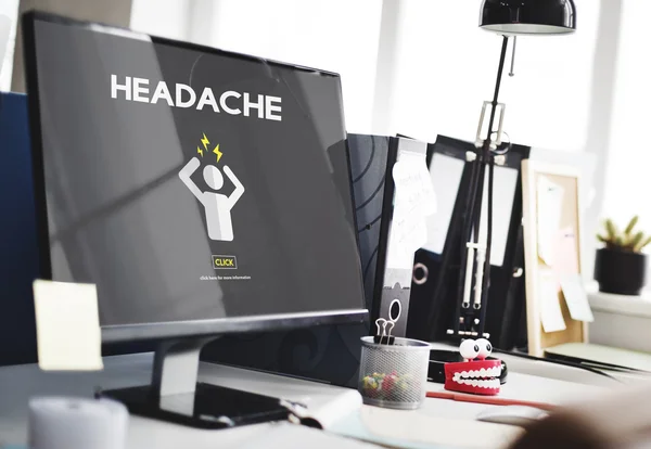 Computer auf dem Tisch mit Kopfschmerzkonzept — Stockfoto