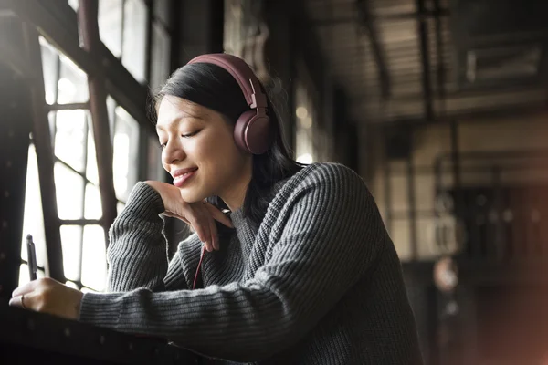 Mulher Ouvindo Música e Escrita em Notebook — Fotografia de Stock