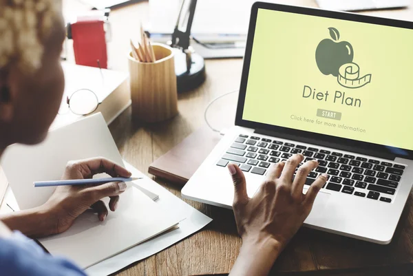 Vrouw die op laptop met dieetplan werkt — Stockfoto