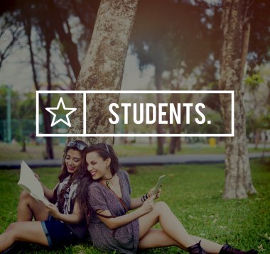 kadın öğrenciler ağacın altında oturuyor