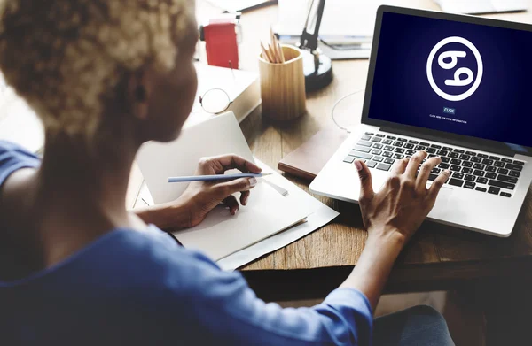Kvinna som arbetar på laptop med zodiac — Stockfoto