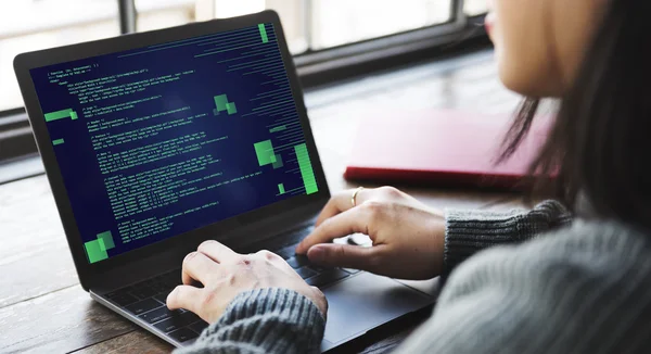 Kvinna som arbetar på laptop med kod — Stockfoto