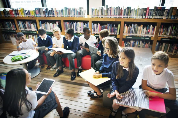 Klasgenoten in de schoolbibliotheek — Stockfoto