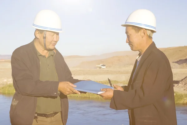 Bauarbeiter in Helmen diskutieren und planen — Stockfoto