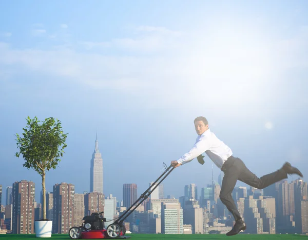 Green Businessman mowing lawn — Stock Photo, Image