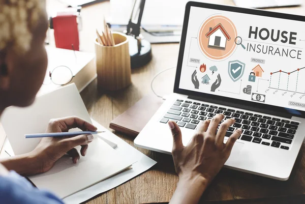 Woman working on laptop with house insurance — Stock Photo, Image