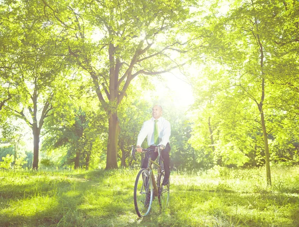 Бизнесмен катается на велосипеде на открытом воздухе — стоковое фото