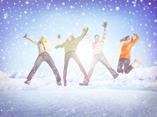 Freunde springen im Schnee — Stockfoto