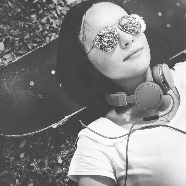 Woman with skateboard and headphones — Stock Photo, Image