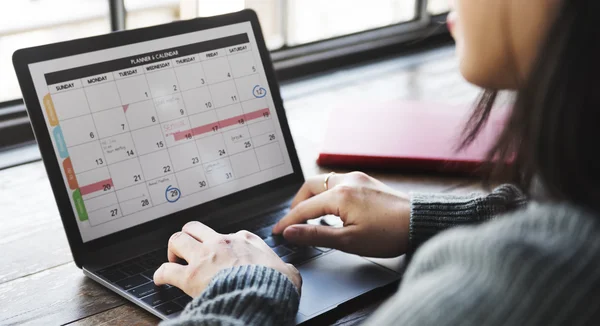 Mulher trabalhando no laptop com calendário — Fotografia de Stock