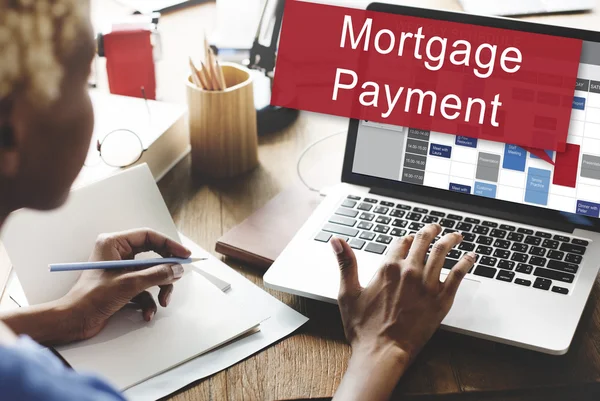 Woman working on laptop with mortgage payment — Stock Photo, Image