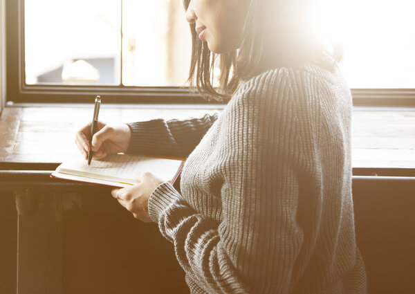 woman writing in notebook 
