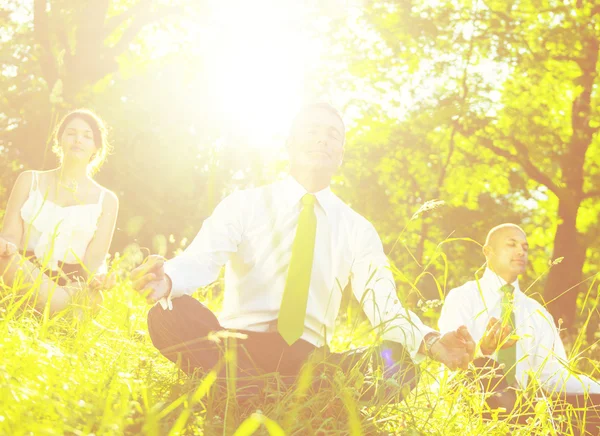 Business people meditating outdoors — Stockfoto