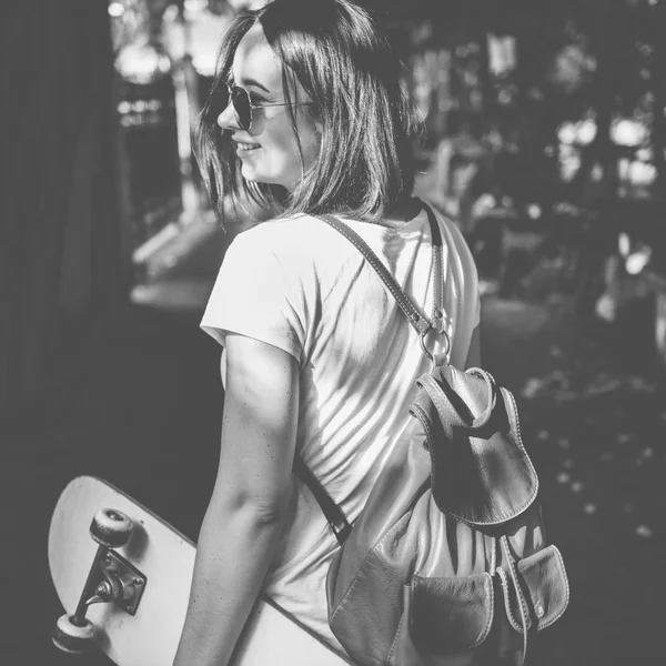 Donna con skateboard e cuffie — Foto Stock