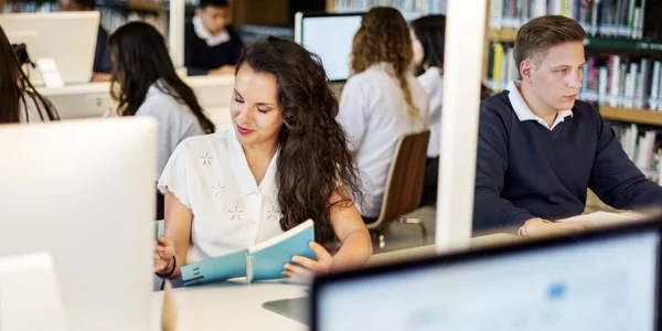 Estudantes usando o computador na biblioteca — Fotografia de Stock