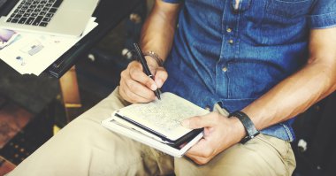 Not defterinde yazılı çalışan adam 