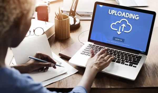 Woman working on laptop with uploading — Stock Photo, Image