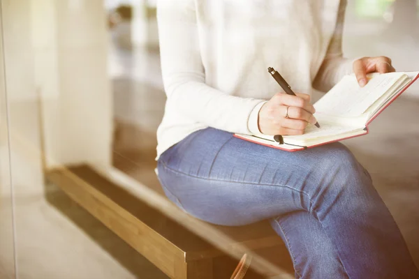 Vrouw schrijven in notebook — Stockfoto