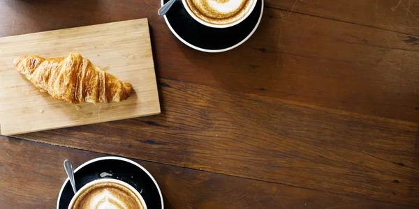 Café et croissant sur la table — Photo